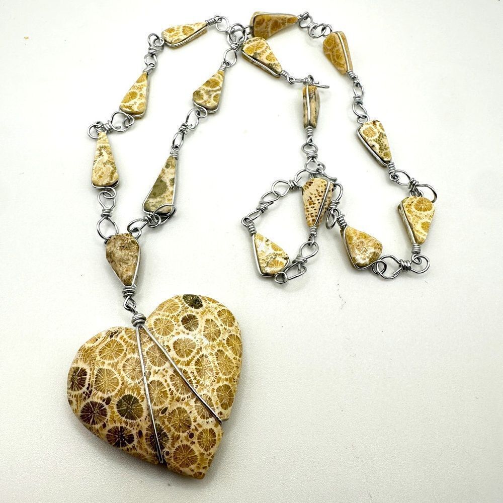 Genuine polished fossilized coral heart necklace in silver tone metal!